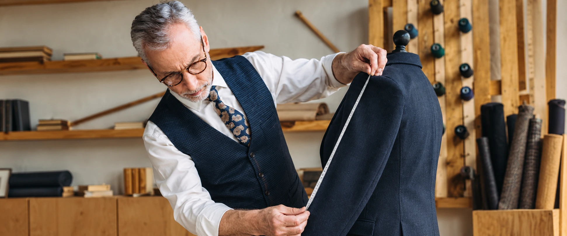 A tailor checking the fit of a jacket